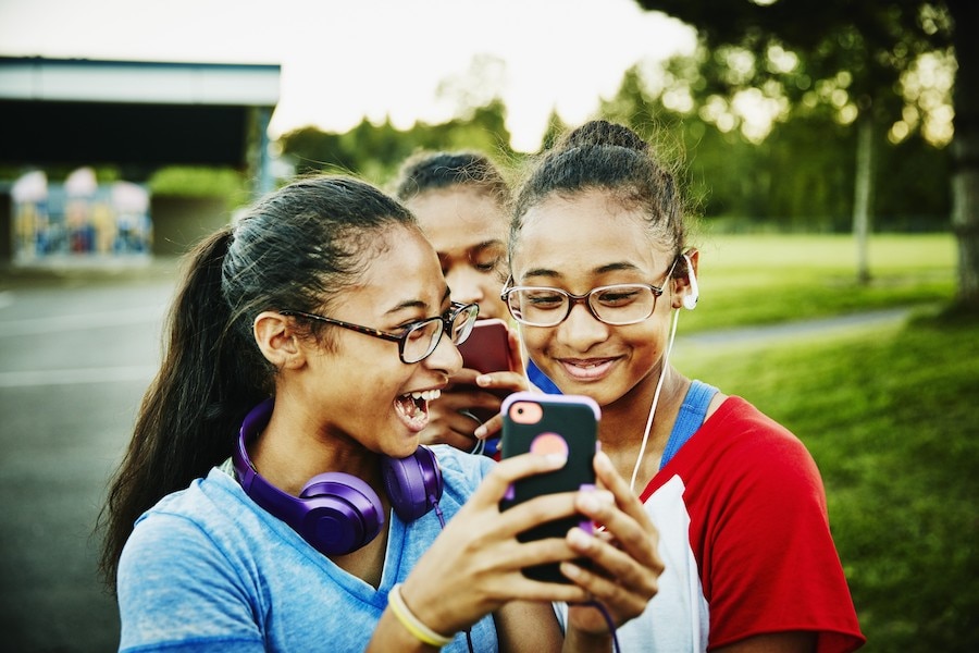 Teenage girls looking at iPhone